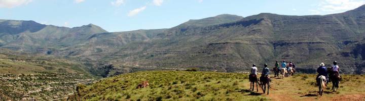 Ruiters te paard in het berglandschap van Lesotho tijdens een groepsrondreis.