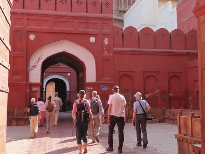 Reizigers lopen door een rode poort naar het fortcomplex in Noord-India.