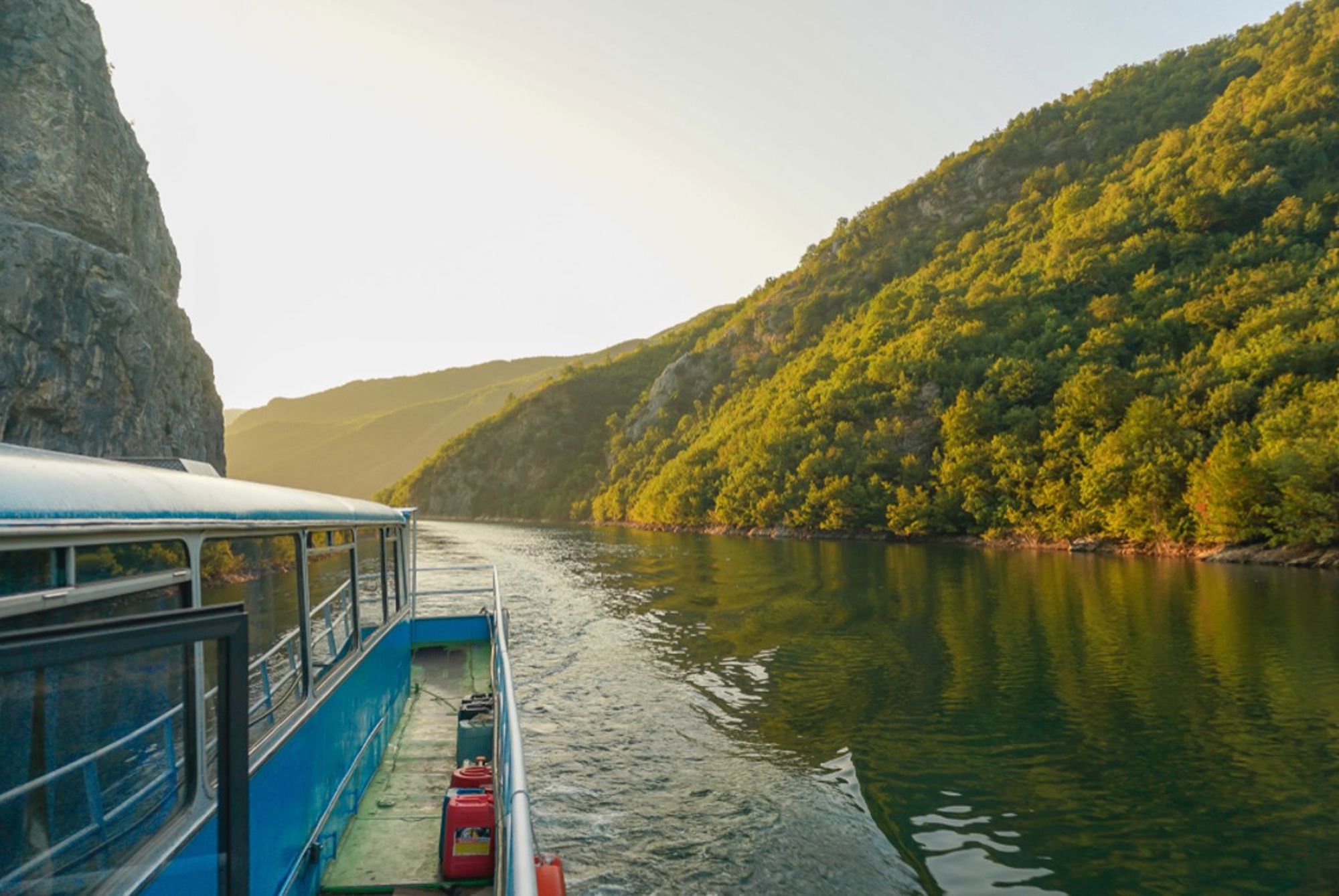 Boottocht door de Komani-meerfjord met groene bergen en rustig water in Albanië.