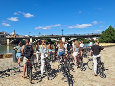 Groepsrondreis Andalusië: fietstocht langs de Guadalquivir met zicht op de Triana-brug in Sevilla.