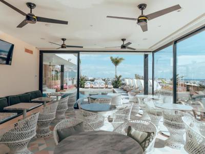 Restaurant en lounge van Calixta hotel met zitjes en uitzicht op het terras en zwembad.