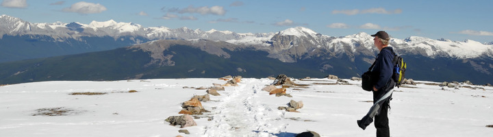 Wandelaar op een besneeuwd plateau met uitzicht op de Rocky Mountains in Canada (Arctic).