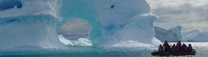 Zodiacboot met reizigers langs ijsbergen in Antarctica tijdens een groepsrondreis.