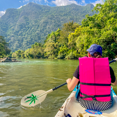 Kanotocht op een rivier tussen groene bergen tijdens 22-35ers reis Thailand, Laos & Cambodja.