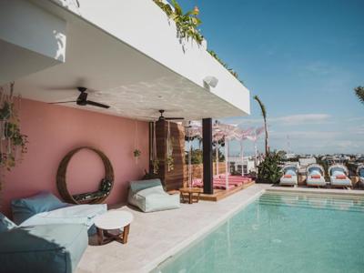 Rooftopterras met zwembad en ligbedden bij Calixta hotel.