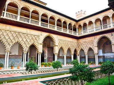 Binnenplaats van het Real Alcázar in Sevilla met Moorse bogen, tegelwerk en waterpartij in Andalusië.