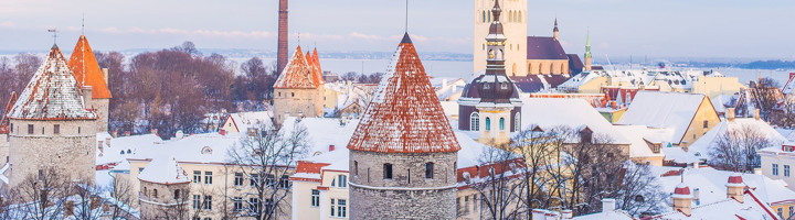 Besneeuwd uitzicht op de oude binnenstad van Tallinn, Estland, met middeleeuwse torens en kerken.