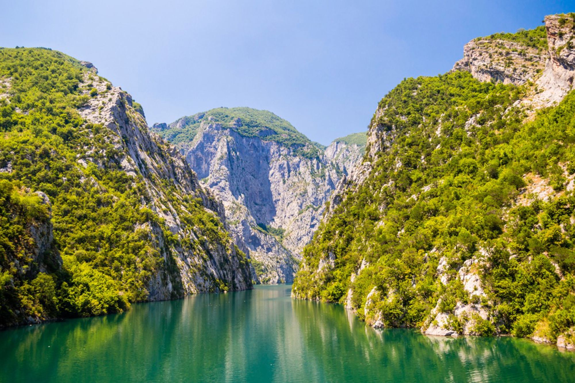 Groene bergkloof met helderblauw meer in Albanië.