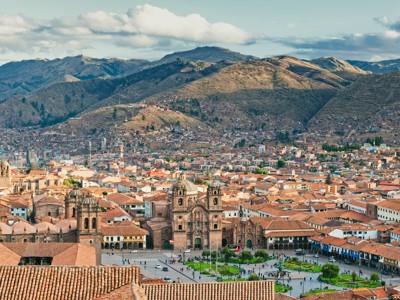 Uitzicht op Plaza de Armas en de kathedraal van Cusco, Peru, met Andesbergen op de achtergrond.