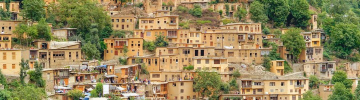 Bergdorp Masuleh met terrasvormige huizen tussen groene heuvels in Iran.